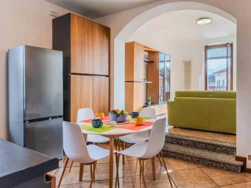 a kitchen with a table and chairs and a refrigerator at Apartment Casa Luvit by Interhome in Menaggio