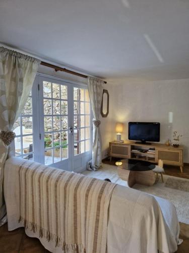 a bedroom with a large bed and a television at Charming house just a few minutes from the beach in Sainte-Maxime