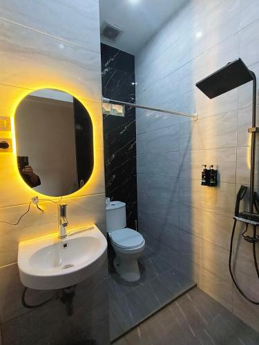 a bathroom with a sink and a toilet and a mirror at Bakom Inn Syariah in Bogor