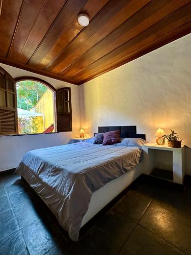 a bedroom with a large bed with a wooden ceiling at Chill House Buzios in Búzios