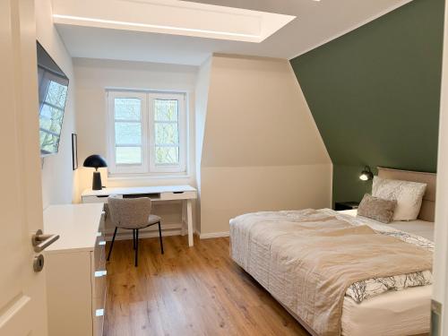 a bedroom with a bed and a desk and a window at Alte Wassermühle Nord in Börm