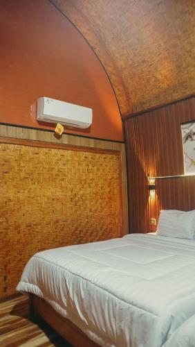 a bedroom with a large bed with a ceiling at Angghy Garden Tetebatu in Tetebatu