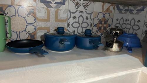 a group of blue pots and pans on a kitchen counter at Vila do Sussurro - Casinha Céu in Triunfo