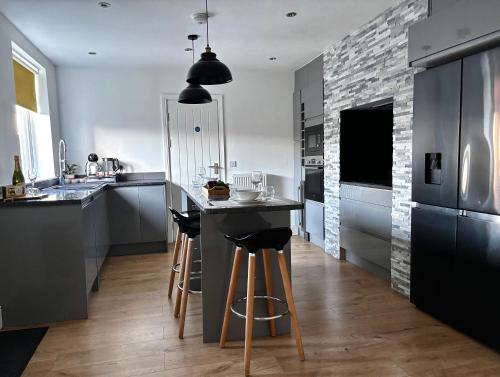 a kitchen with a bar with stools in it at Holdsworth House Apartments in Killingbeck