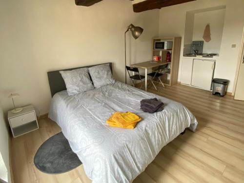 a bedroom with a bed with a yellow towel on it at Charmant studio à Viens in Viens