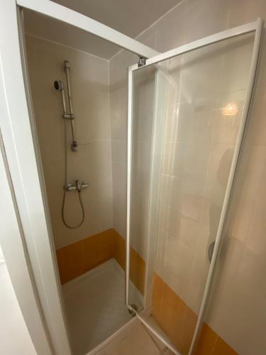 a shower with a glass door in a bathroom at Charmant studio à Viens in Viens