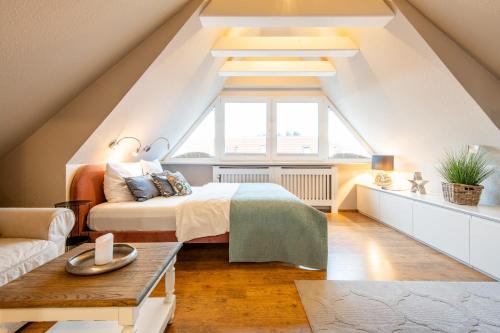 a attic bedroom with a bed and a window at Princessa Coast in Süderende