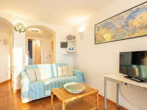 a living room with a blue couch and a tv at Apartment Mare 8 by Interhome in Porto Cervo