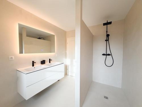 a white bathroom with a sink and a mirror at Alte Wassermühle Süd in Börm