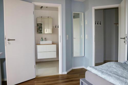 a bedroom with a bathroom with a sink and a mirror at Seeluft in Warin