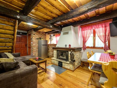 a living room with a fireplace and a table at Chalet Pine Hill by Interhome in Klenovnik