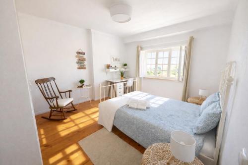 a bedroom with a bed and a chair and a window at Ericeira -Oceonview Villa with Pool and Whirlpool in Ericeira