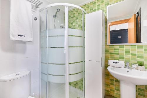 a bathroom with a shower and a toilet and a sink at Las Dunas 213 - by Welcomely in Oliva