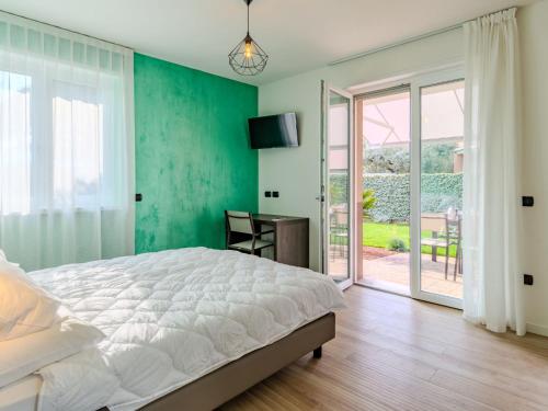 a bedroom with a bed and a desk and a window at Apartment Garda Oasis by Interhome in Riva del Garda