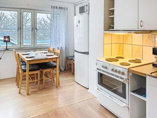a kitchen with a table and a stove and refrigerator at Apartment Stadsro by Interhome in Vimmerby