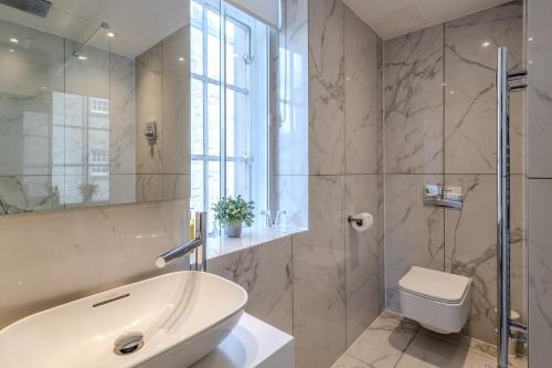 a bathroom with a tub and a toilet and a sink at The Inn on the Mile in Edinburgh