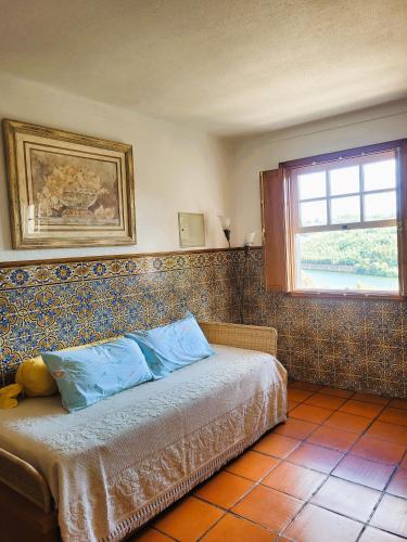 a bedroom with a bed in a room with a window at Quinta da Xistosa in Foz do Sousa