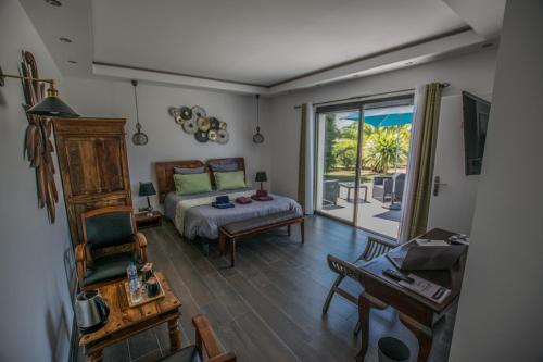a bedroom with a bed and a sliding glass door at Les Cuves - Saintes - Chambres d'hôtes et gîte in Saintes