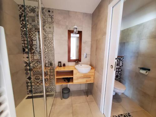 a bathroom with a sink and a shower at Les Cuves - Saintes - Chambres d'hôtes et gîte in Saintes