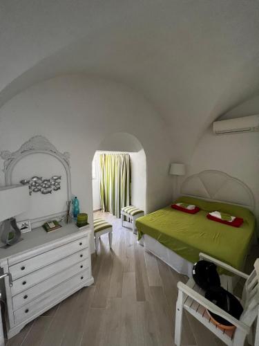 a bedroom with a bed and a dresser and a mirror at Villa Croce Anacapri in Anacapri