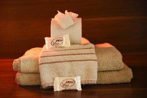 a stack of towels with tags on them at Hotel Volp Patos in Patos de Minas
