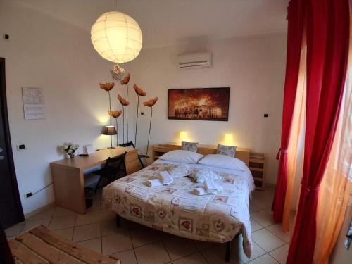 a bedroom with a large bed and a desk at B&B Salviani in Acilia