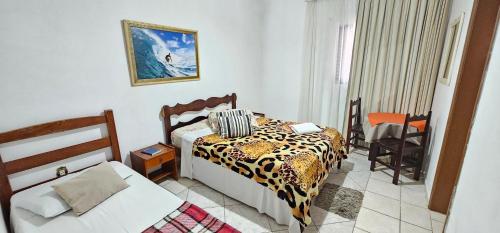 a bedroom with a bed with a leopard print blanket at Pousada Hotel Casarão SerraNegra in Serra Negra