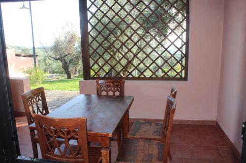 una mesa de madera y sillas en una habitación con ventana en Residence Hotel Torresilvana, en Vieste
