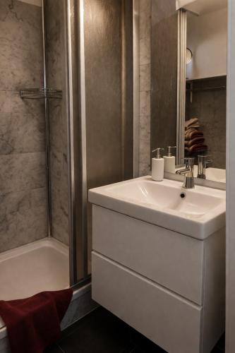 a bathroom with a white sink and a shower at Ferienwohnungen Vidoni in Bodensdorf