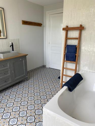 a bathroom with a tub and a ladder next to a sink at La Romanee d Or in Marchampt