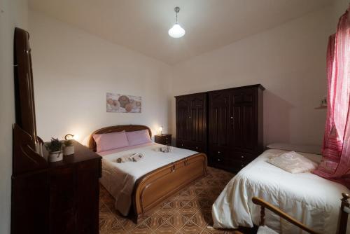 a bedroom with two twin beds and a dresser at Apartment Su Cramu in Villacidro
