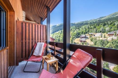 two chairs and a table on a balcony with a view at Résidence Pierre & Vacances Le Peillon in Méribel
