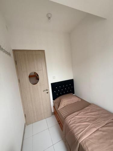 a small bedroom with two beds and a door at Modern 2BR Apartment With Fast WiFi in Rawalumpang