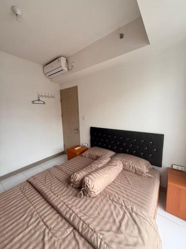 a bedroom with a large bed with pillows on it at Modern 2BR Apartment With Fast WiFi in Rawalumpang