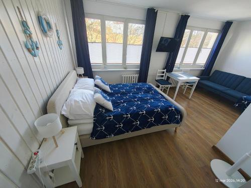a small bedroom with a bed and a couch at Gryfhaus - Pokój Kapitański, 19m2, blisko plaży, parking, wysoka ocena 9,5, 2-4 osoby in Międzyzdroje