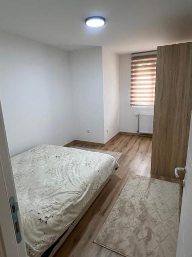 an empty bedroom with a bed and a window at Stan na dan Stanojević in Bratunac