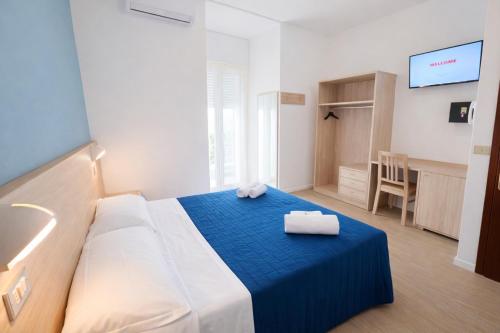 a hotel room with a bed with a blue blanket at Hotel Damma's, Dipendenza Zamagna in Cesenatico