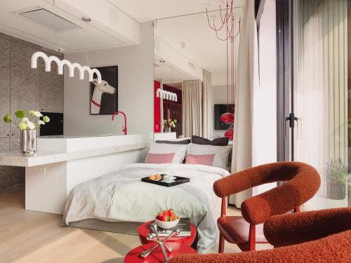 a bedroom with a bed and a table and a chair at Scarlet Jacuzzi Suit by Sofija in Warsaw