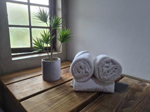 a room with towels on a wooden floor with a plant at Fairway Guest Lodge in Margate