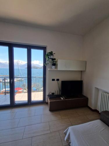 a bedroom with a view of the ocean from a balcony at Luxury casa Margherita in Pianello Del Lario