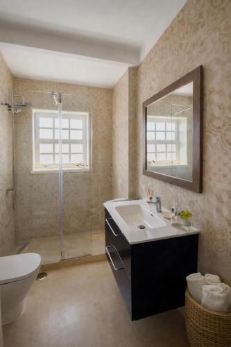 a bathroom with a sink and a toilet and a mirror at Ericeira -Oceonview Villa with Pool and Whirlpool in Ericeira