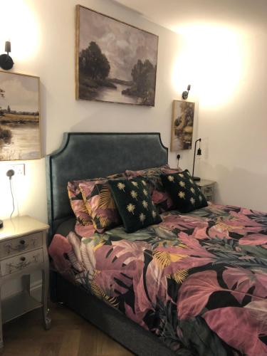 a bedroom with a bed and a table with a night stand at harbourways in Looe
