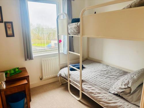a bedroom with bunk beds and a window at 4 bed Townhouse with spectacular views 4 miles from Cardiff 10min drive or train journey to city centre in Cardiff