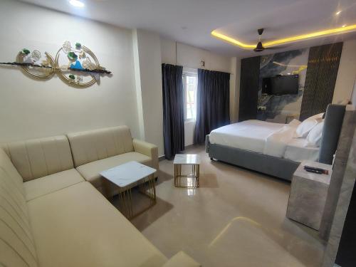 a hotel room with a bed and a couch at HoTEL MOKSHA GRAND in Vijayawāda