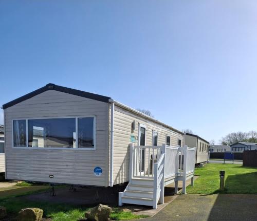 a mobile home with a porch and a staircase at Buckingham Breeze Haven Caravan Hire Marton Mere Blackpool in Marton