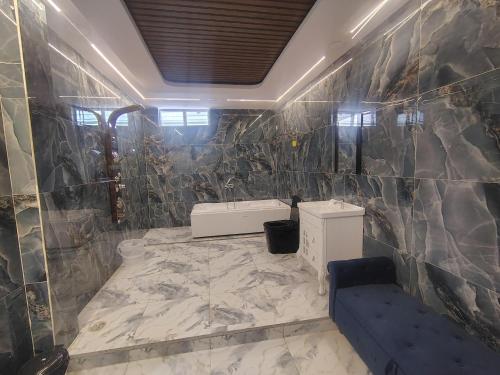 a bathroom with a tiled wall with a sink at HoTEL MOKSHA GRAND in Vijayawāda