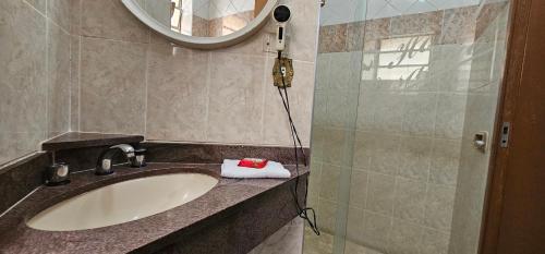 a bathroom with a sink and a mirror at Pousada Hotel Casarão SerraNegra in Serra Negra