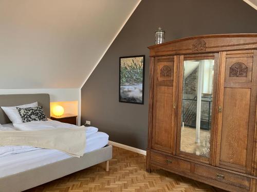 a bedroom with a wooden cabinet and a bed at freiheitACHT in Raesfeld