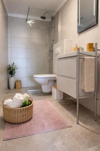 a bathroom with a toilet and a basket of towels at Abby Apartment Koper in Koper