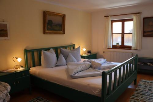 a bedroom with a bed with white pillows and a window at Ferienwohnungen Thomafischer in Chieming